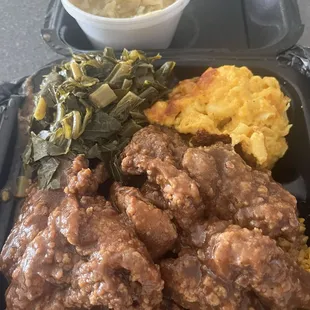 Smothered pork chops over yellow rice, Mac and cheese, collard greens, extra side of cabbage.