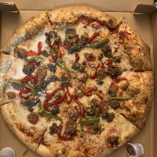 Vegan pizza with green and red peppers, vegan meat, and sausage