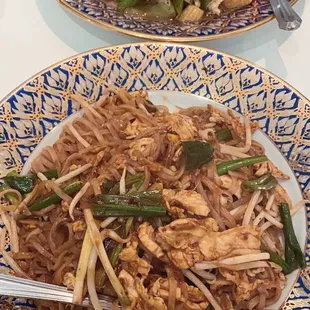 Garlic pepper chicken in back, pad Thai in front