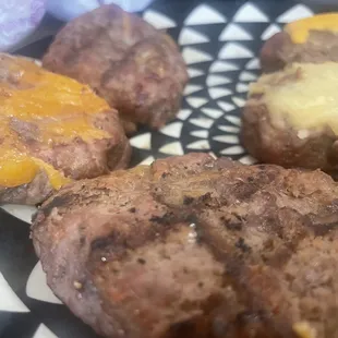 a plate of hamburgers with cheese