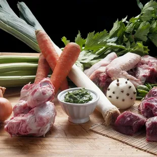 a variety of meat and vegetables on a cutting board