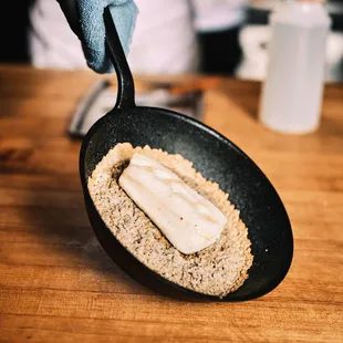 a person holding a frying pan with food in it