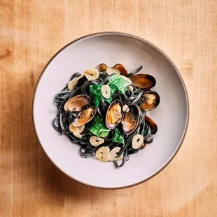a bowl of pasta with clams and spinach