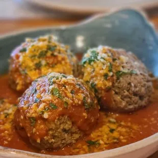 a plate of meatballs covered in tomato sauce