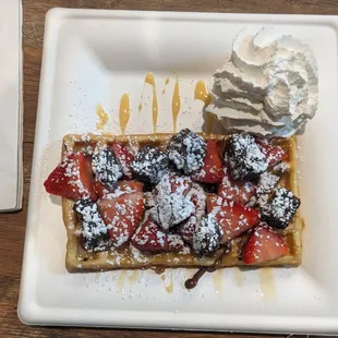 a waffle topped with strawberries and whipped cream
