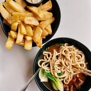 a bowl of noodles and french fries