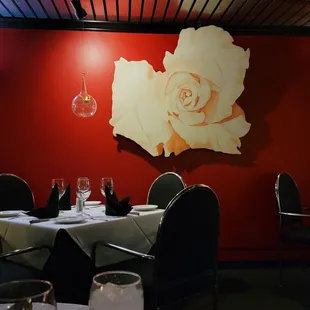 a dining room with red walls and black chairs