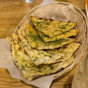 Chili cheese naan in front with garlic naan behind (4 pc to an order, one chili cheese naan eaten )