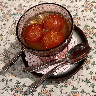 a bowl of tomato soup with spoons