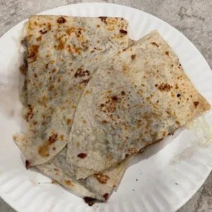 two quesadillas on a paper plate