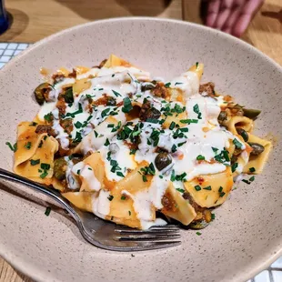 pappardelle pasta with beef heart bolognese, capers, grilled olives and taleggio fonduta