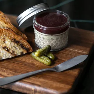 a sandwich and pickles on a cutting board