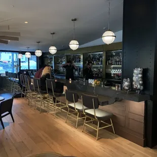 a view of a bar with chairs and tables