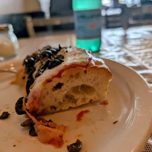 Sicillian style slice of pizza with mushrooms and black olives and garlic.