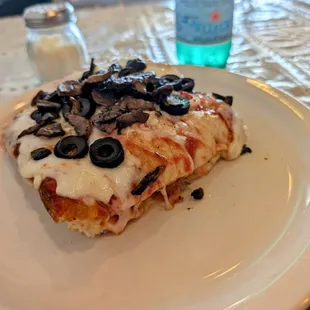 Sicilian style crust slice of pizza with mushrooms, black olives, and garlic.