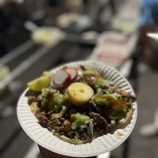 a person holding a plate of tacos