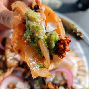 a hand holding a tortilla