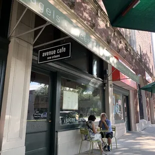 two people sitting at a table outside