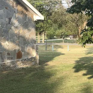 a stone building with a green lawn