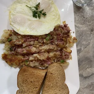 Corned beef hash over easy egg and toast