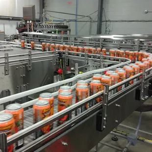 orange cans on a conveyor belt