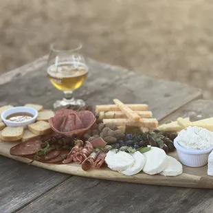  a platter of cheese, meats, crackers, and bread