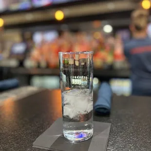ows a glass of water on a bar