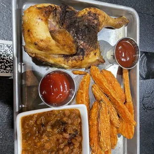 Half chicken plate with baked beans and sweet potato wedges