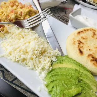 I can&apos;t remember the name of this dish but it&apos;s scrambled eggs with onions/tomatoes, cheese, avocado, and an arepa. Definitely delicious