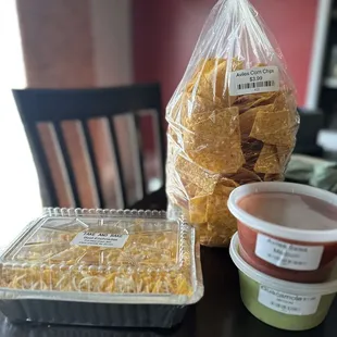 a bag of chips and a container of salsa
