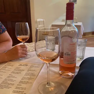 a woman sitting at a table with a glass of wine