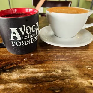 Black drip coffee in black cup, cinnamon chi latte in white cup