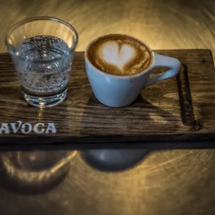 a cup of cappuccino and a glass of water