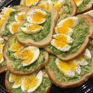 Tray of avocado toast w/ soft boiled egg