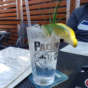 a tall glass of water with a lemon wedge