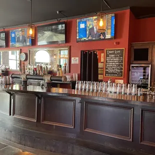 a bar with a row of empty glasses on the counter