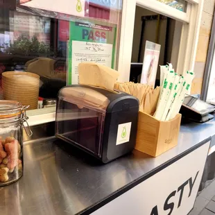 Counter space with dog treats and compostable utensils and straws.