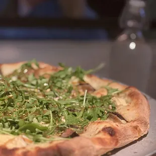 a pizza topped with arugula