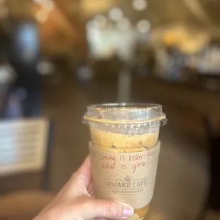 a hand holding a cup of coffee