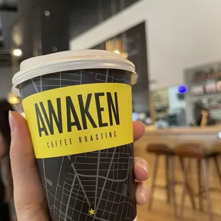 a hand holding a coffee cup