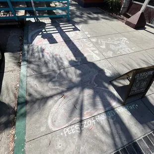 a sidewalk with chalk writing on it