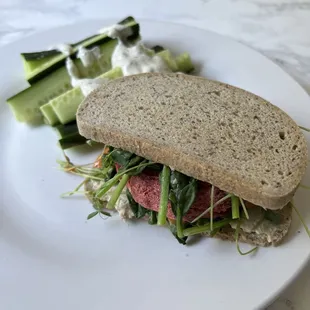 a sandwich and cucumbers on a plate