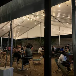 a group of people sitting under a tent