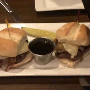 a plate with two sandwiches and a pickle