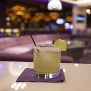 a cocktail with a lime slice on the rim