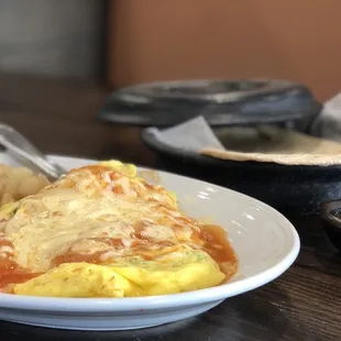 Machamigas Plate with beef fajita meat, scrambled eggs, refried beans, potatoes and flour tortillas