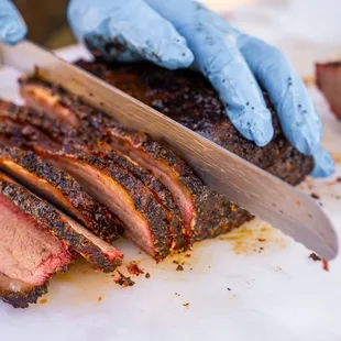 a person cutting meat on a cutting board