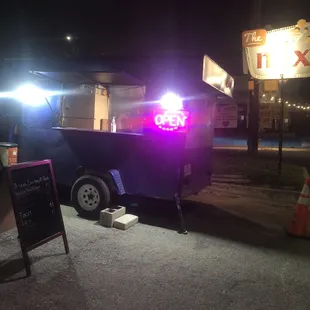 a food truck with its lights on