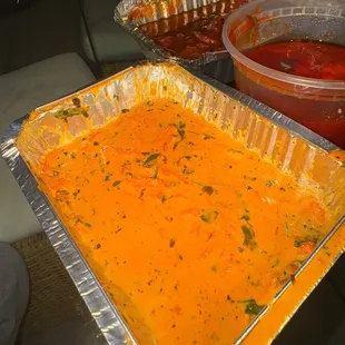 a pan of soup and a container of sauce