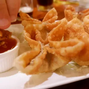 a person dipping sauce into fried food